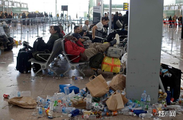 据报道，巴塞罗那机场的旅客不得不在垃圾堆中前行。他们拉着行李穿过满地的垃圾，要在垃圾堆中排队，连在大堂座位上休息时，都被满地的垃圾包围。 